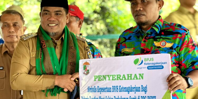 Bupati H.Zukri Serahkan Secara Simbolis BPJS Ketenagakerjaan bagi Buruh Bongkar Muat Perkebunan Kelapa Sawit